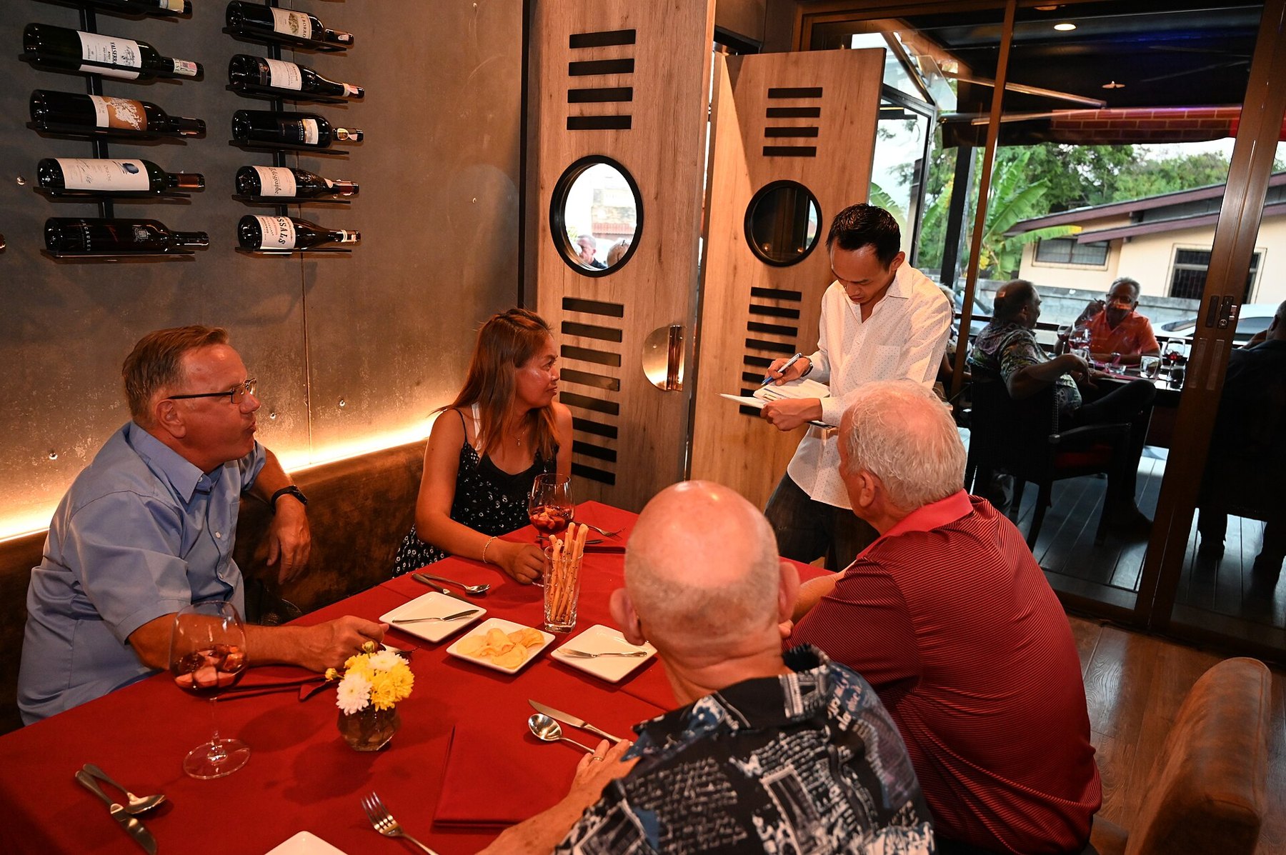 Assiette de poulet grillé posée sur une table de restaurant, avec un menu en arrière-plan