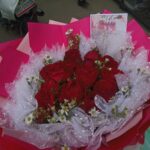 Bouquet de roses rouges posé sur une table claire, illustrant le langage des fleurs et les quiz amoureux