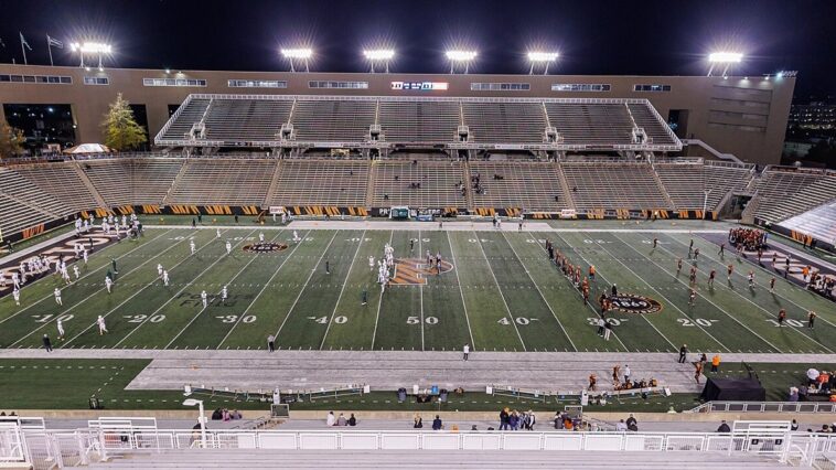 Un stade de football américain éclairé la nuit, symbole de la NFL au cœur d'une polémique médicale autour d'un quarterback