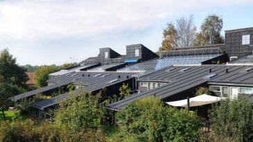 Adolescent assis dans une cuisine éclairée la nuit, à côté d'un réfrigérateur ouvert, dans une ambiance familiale détendue