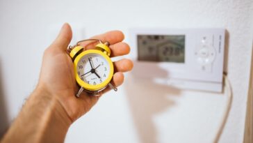 Vieux réveil posé sur une table en bois, symbole du temps qui passe et des âges qui s'accumulent