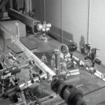 Faisceau laser traversant un laboratoire de physique sombre, illustrant les expériences d'optique quantique