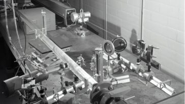 Faisceau laser traversant un laboratoire de physique sombre, illustrant les expériences d'optique quantique