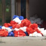 Sacs de courses en tissu réutilisables posés sur une table en bois, à côté de bocaux en verre