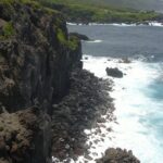 Paroi verticale de colonnes de basalte serrées au milieu d'une forêt de montagne tropicale